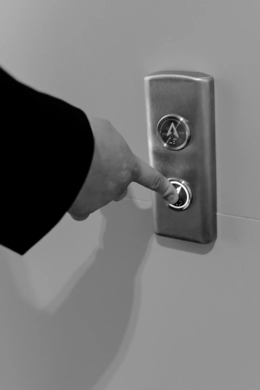 a black and white photo of a person pressing a button, secret entrance, ascending, uploaded, silver