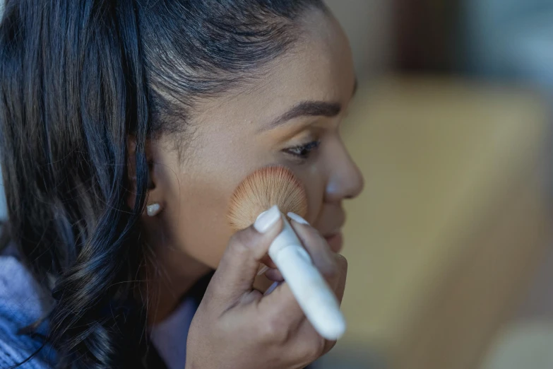 a woman brushes her face with a brush, pexels contest winner, hurufiyya, light tan, contour, fan favorite, dark skinned