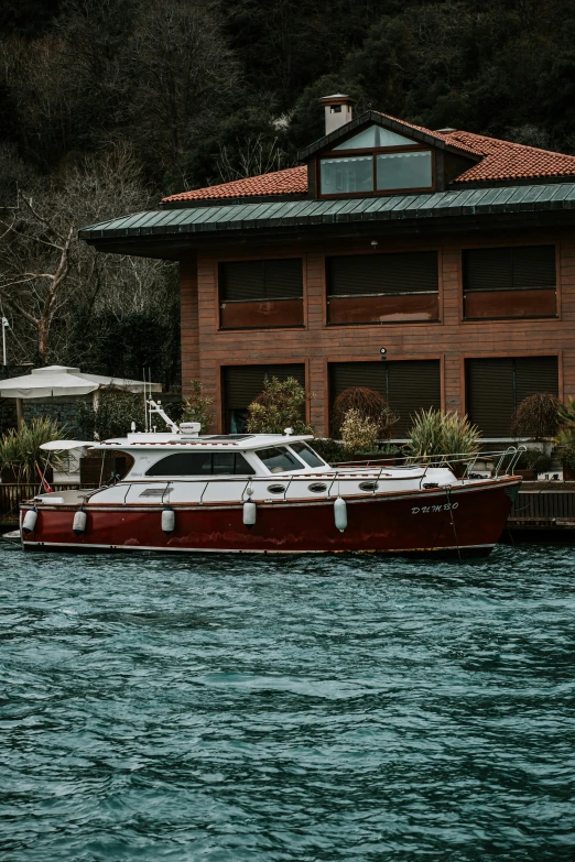 a boat that is sitting in the water, peaceful wooden mansion, color ( sony a 7 r iv, red brown and white color scheme, 💋 💄 👠 👗