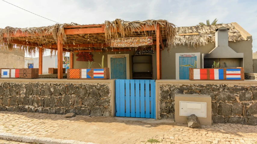 a building with a thatched roof and a blue door, beach bar, freddy mamani silvestre facade, afar, thumbnail