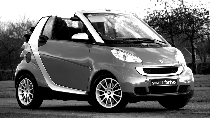 a black and white photo of a smart car, convertable, orange grey white, square, medium shoot