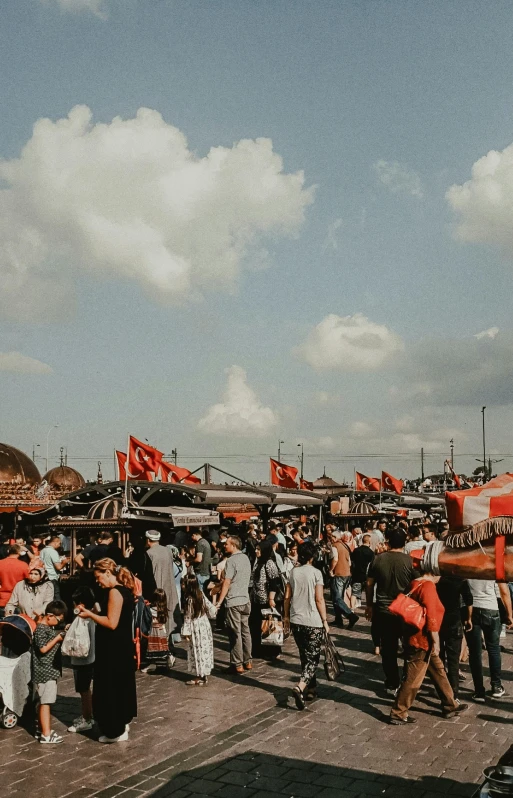 a group of people standing on top of a pier, street market, red flags holiday, turkish and russian, skies