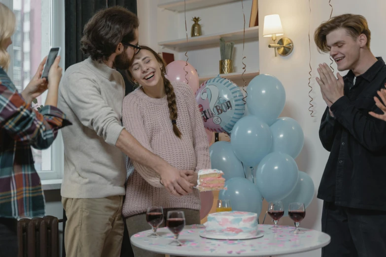 a group of people standing around a table with balloons, maternity feeling, grey and blue theme, h3h3, indoor scene