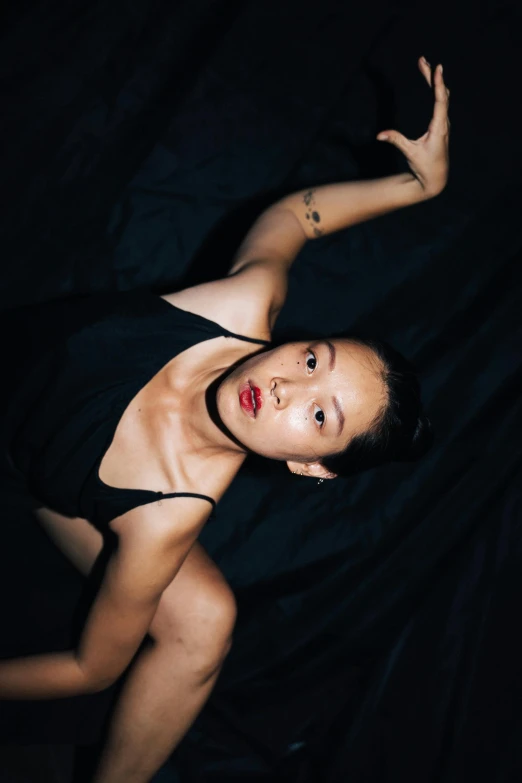 a woman in a black dress posing for a picture, an album cover, inspired by Taro Yamamoto, unsplash, neo-figurative, laying back on the bed, kiko mizuhara, she is wearing a black tank top, asian descent