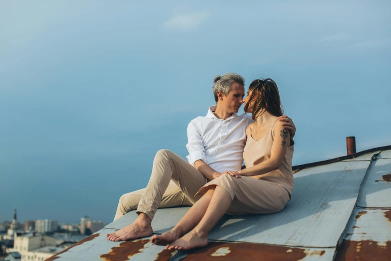 a man and a woman sitting on top of a roof, a portrait, by Lee Loughridge, pexels contest winner, romantic, seaview, profile image, flattened