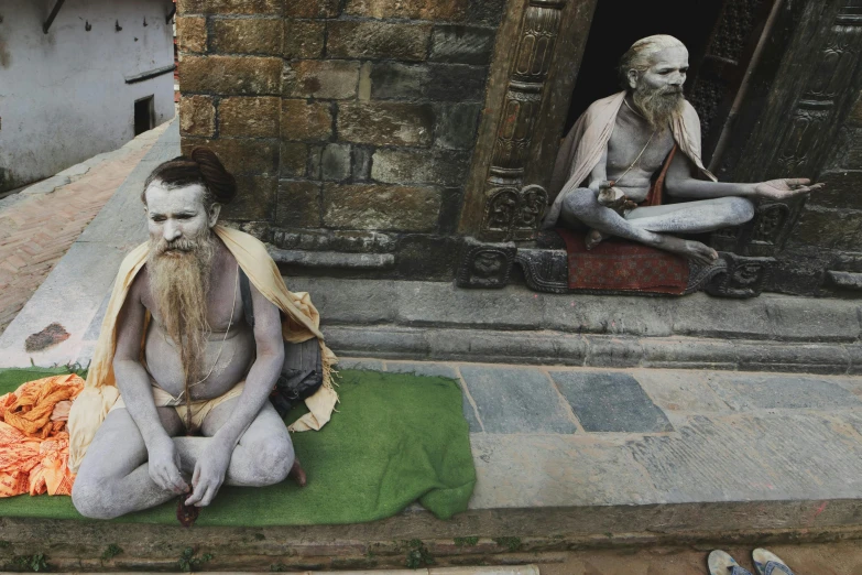 a man sitting on a mat in front of a building, pexels contest winner, hyperrealism, 3 spring deities, two skinny old figures, nepal, loincloth