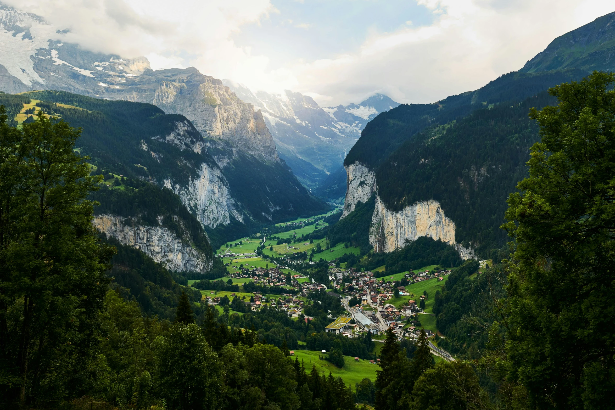 a view of a valley with mountains in the background, by Daniel Seghers, pexels contest winner, renaissance, lauterbrunnen valley, slide show, zoomed out to show entire image, conde nast traveler photo