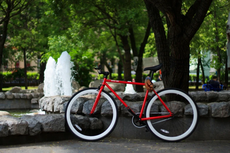 a red bike parked in front of a fountain, pexels contest winner, white wheel rims, seoul, replicas, profile pic