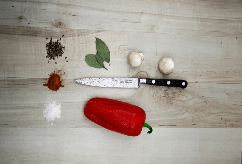 a knife sitting on top of a wooden table, pepper, detailed product image, my little everything, full product shot