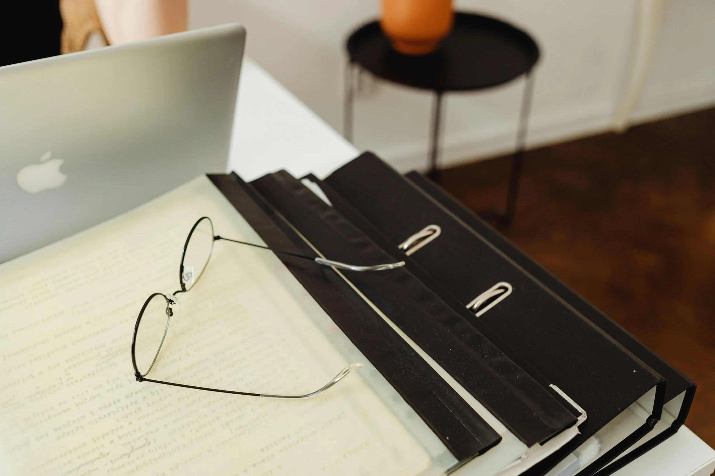 a laptop computer sitting on top of a stack of books, an album cover, by Carey Morris, unsplash, visual art, square rimmed glasses, closeup - view, holding a clipboard, black rimmed glasses