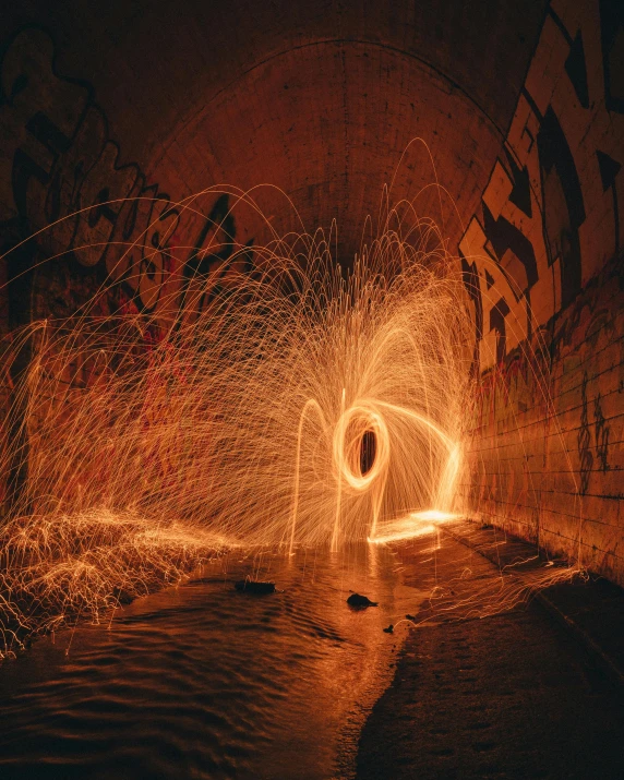 a light painting in the middle of a tunnel, unsplash contest winner, graffiti, fire and water, instagram picture, glitter, gold and red metal