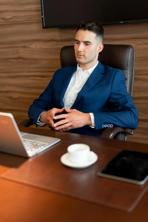 a man sitting at a desk in front of a laptop computer, a portrait, pexels, dressed in expensive clothes, hip corporate, thumbnail, thoughtful )