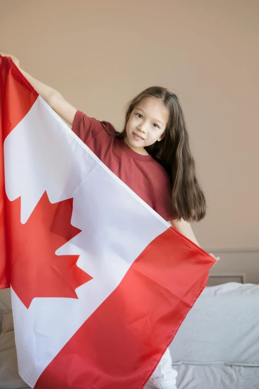 a little girl holding a canadian flag on a bed, pexels contest winner, symbolism, a young asian woman, programming, 2070, raptors