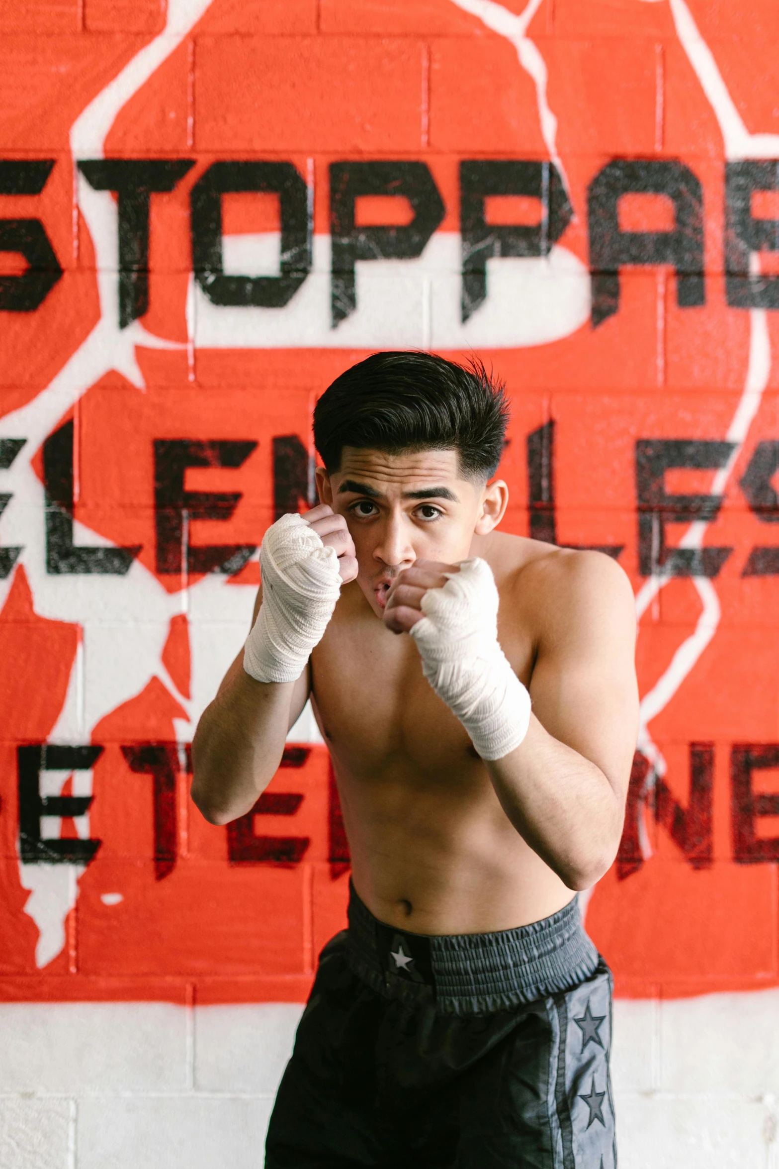 a man that is standing in front of a wall, by Robbie Trevino, happening, boxing gloves, asher duran, shoulders up, press photos