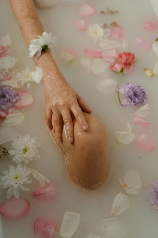 a person laying in a bath filled with flowers, holding hands, silicone skin, soft shade, pale skin