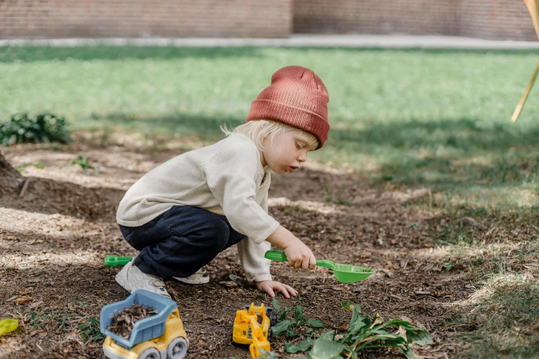 a little boy that is playing in the dirt, inspired by Elsa Beskow, pexels contest winner, visual art, caracter with brown hat, sustainable materials, parks and gardens, mini model