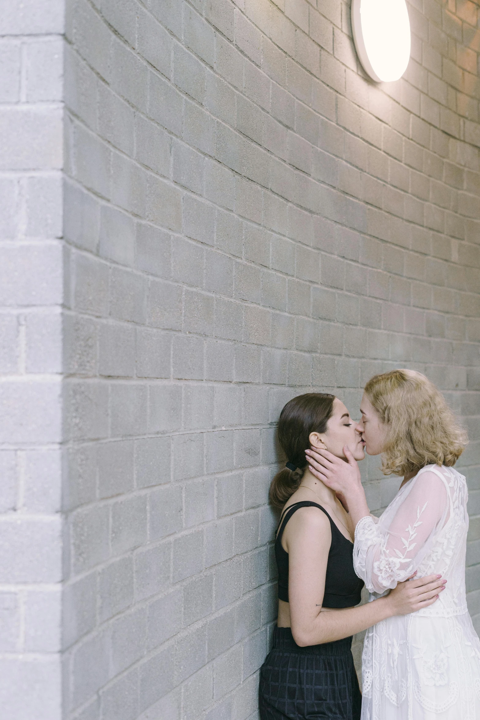 a couple of women standing next to each other, inspired by Nan Goldin, unsplash, renaissance, lovely kiss, low quality footage, on a wall, wedding