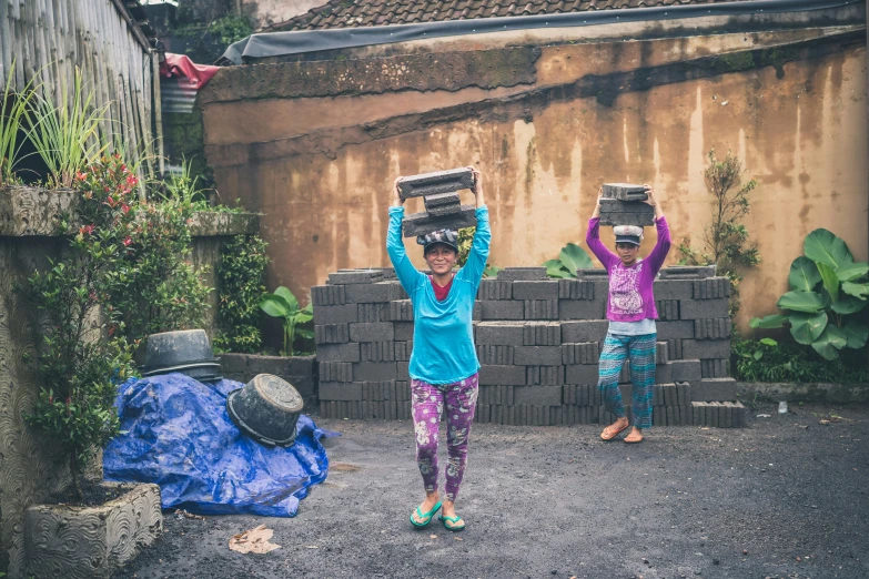 two young girls carrying bricks on their heads, pexels contest winner, mai anh tran, avatar image, worksafe. instagram photo, grey