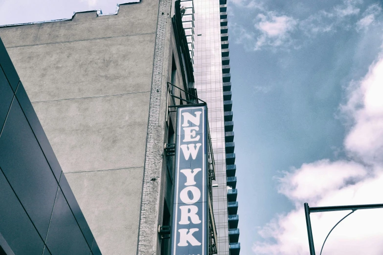 a sign that is on the side of a building, a photo, by Carey Morris, unsplash, art nouveau, watching new york, photographic print, billboard image