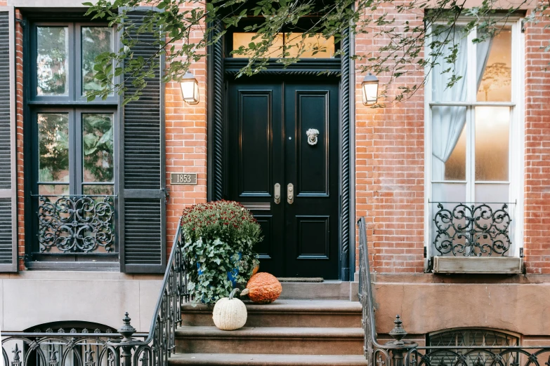 a black door sitting on the side of a brick building, pexels contest winner, arts and crafts movement, city apartment cozy calm, carriage made of pumpkins, lush brooklyn urban landscaping, profile image