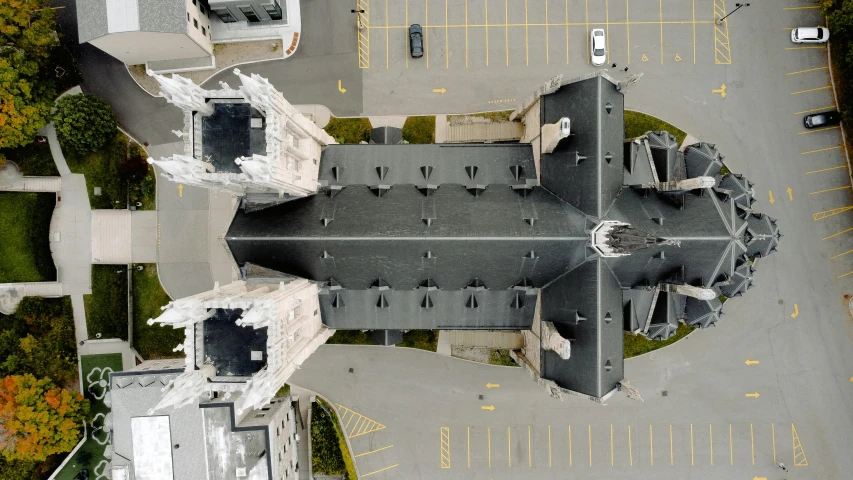 an aerial view of a building in a parking lot, an album cover, by Karel Dujardin, unsplash contest winner, chartres cathedral, quebec, 360 foot wingspan, taken in 2022