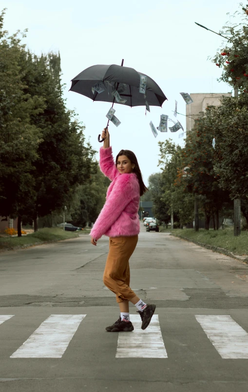 a woman crossing a street holding an umbrella, an album cover, pexels contest winner, graffiti, coat for a rave with fur, money falling from the sky, high quality photo, artem chebokha