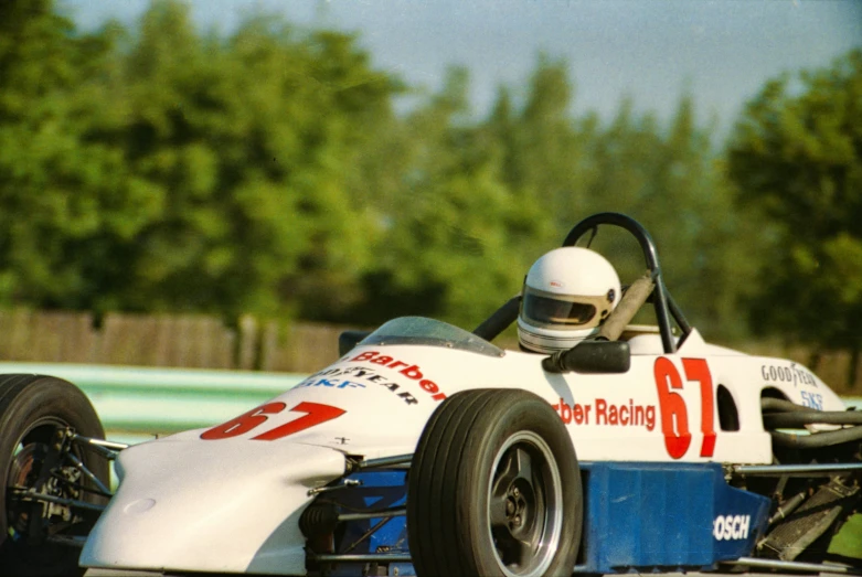 a man driving a race car on a track, vhs colour photography, delightful surroundings, robert maplethorpe, old school fpr