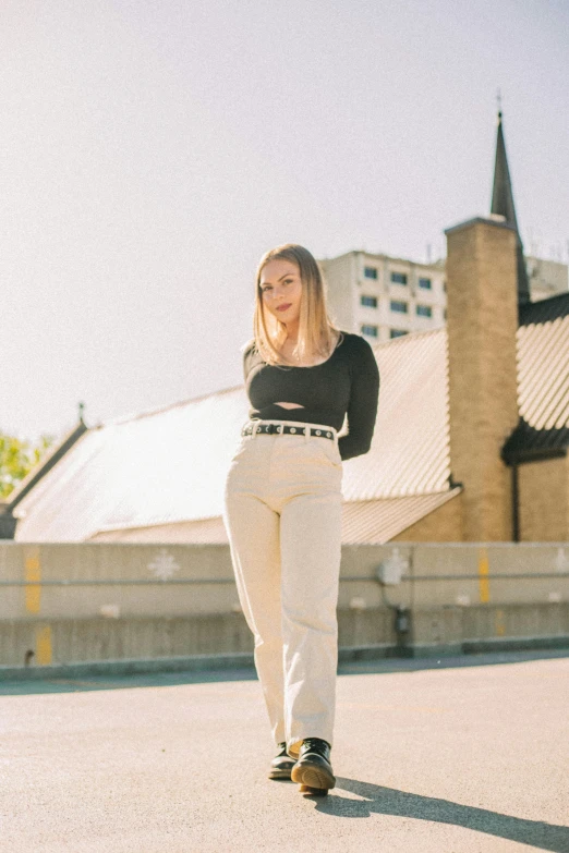 a woman riding a skateboard down a street, an album cover, by Marshall Arisman, unsplash, renaissance, white pants, standing on a rooftop, sydney sweeney, wearing elegant casual clothes