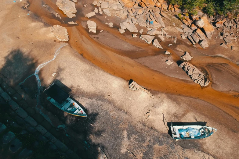 a couple of boats sitting on top of a sandy beach, inspired by Filip Hodas, unsplash contest winner, photorealism, birdseye view, erosion channels river, “ iron bark, thumbnail