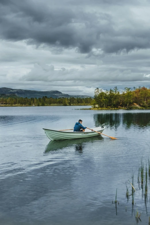 a man in a row boat on a lake, inspired by John Lavery, unsplash, hurufiyya, ireland, colour photograph, 4k shot, slate