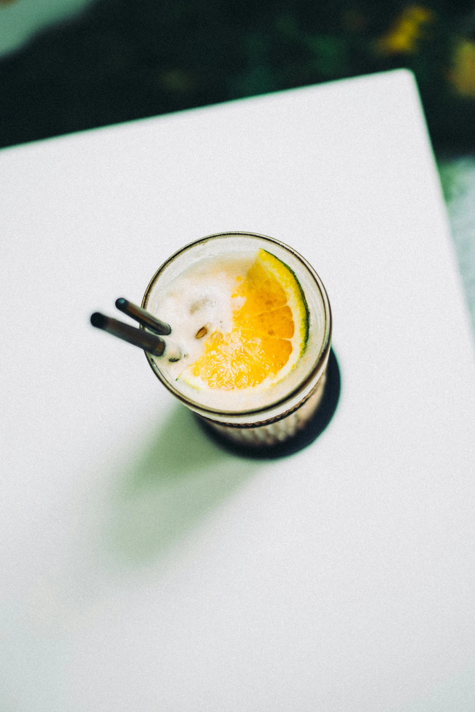 a drink sitting on top of a white table, by Carey Morris, unsplash, straw, birdseye view, lemon, historical photo