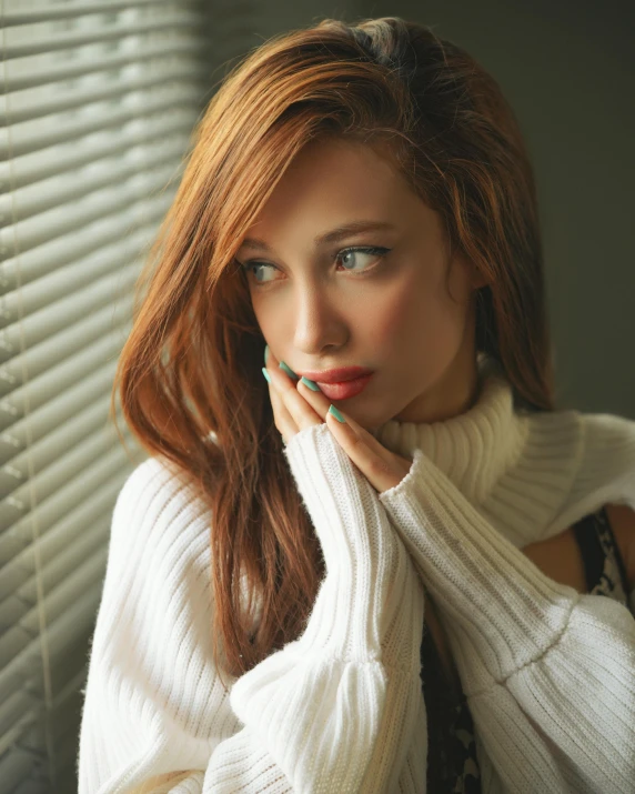 a woman in a white sweater leaning against a window, inspired by Elsa Bleda, trending on pexels, renaissance, light-red lips, redhead, asian women, androgynous male