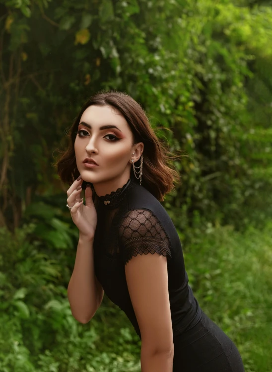 a woman in a black dress posing for a picture, an album cover, inspired by Elsa Bleda, trending on pexels, renaissance, outdoor photo, sasha grey, 60mm portrait, lush and green