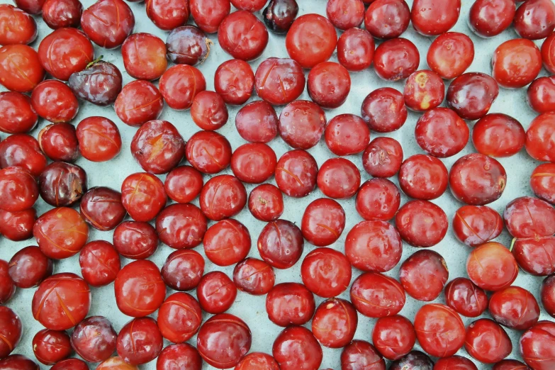 a pile of red grapes sitting on top of a table, by Jan Rustem, pexels, process art, submerged in cranberries, tomatoes, made of glazed, thumbnail