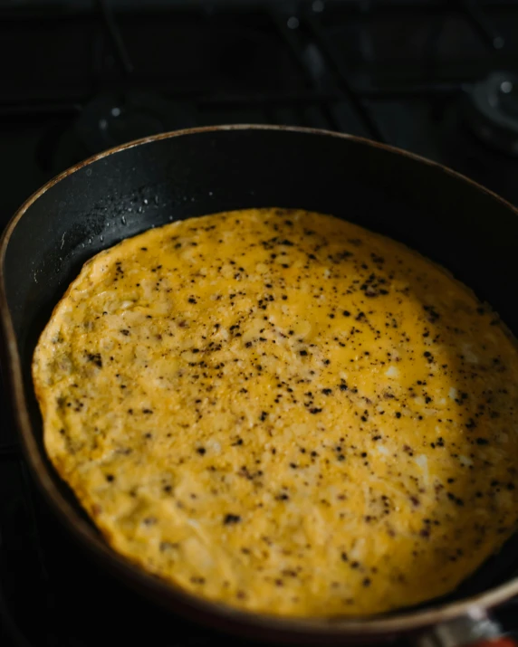 a pan filled with food sitting on top of a stove, a stipple, trending on reddit, hurufiyya, vibrant but dreary gold, crust, taken with sony alpha 9, manta ray made of pancake