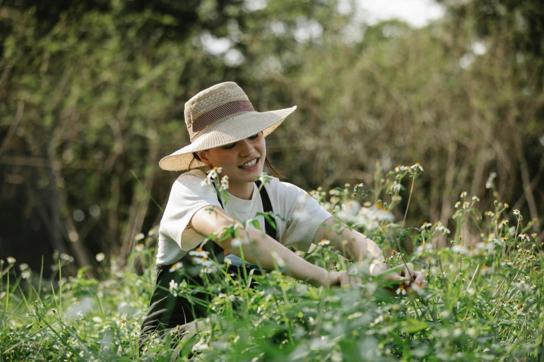 a woman in a hat picking flowers in a field, ecovillage, avatar image, bo chen, thumbnail