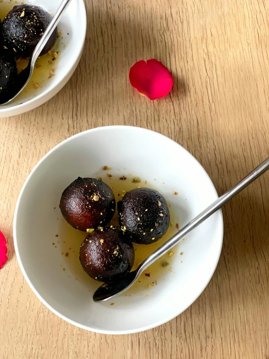 a couple of bowls of food on a table, mangosteen, black oil bath, gold flaked flowers, 1 8 mm