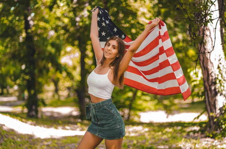 a beautiful young woman holding an american flag, pexels contest winner, wearing crop top and miniskirt, 🚿🗝📝, profile image, having a good time