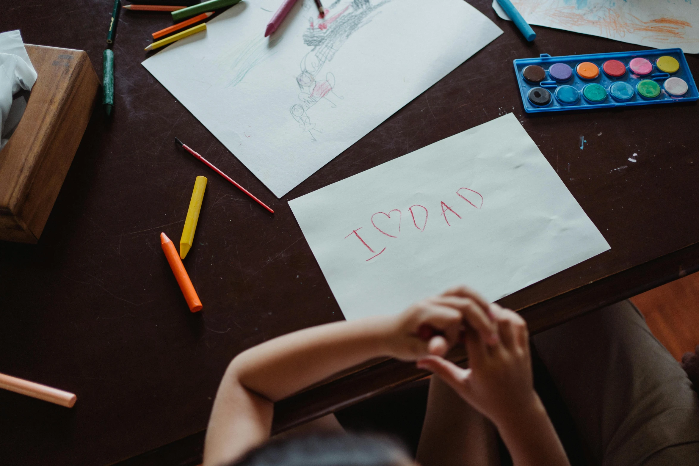 a child is sitting at a table with crayons, a child's drawing, by Emma Andijewska, pexels contest winner, cool dad vibes, instagram story, a high angle shot, 15081959 21121991 01012000 4k