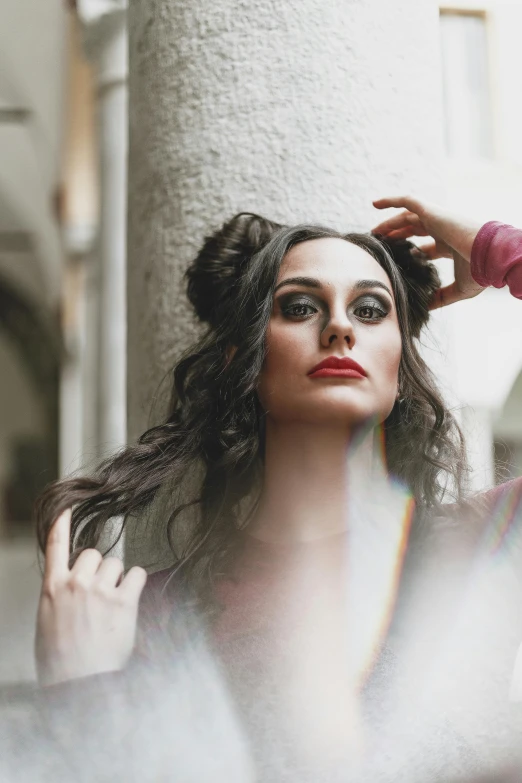 a woman putting her hair in front of a mirror, a portrait, inspired by Lucia Peka, pexels contest winner, renaissance, gothic city streets behind her, gorgeous kacey rohl, drag, square