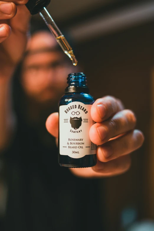 a person holding a bottle of beard oil, thumbnail, stephan, trimmed, f / 1