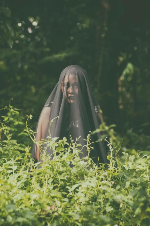 a woman standing in the middle of a lush green forest, an album cover, unsplash, conceptual art, an evil nun, photo of a black woman, southern gothic scene, concert