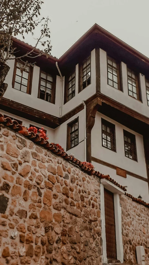 a tall building sitting next to a stone wall, by Tamas Galambos, pexels contest winner, art nouveau, ottoman sultan, cottage close up, 15081959 21121991 01012000 4k, thumbnail
