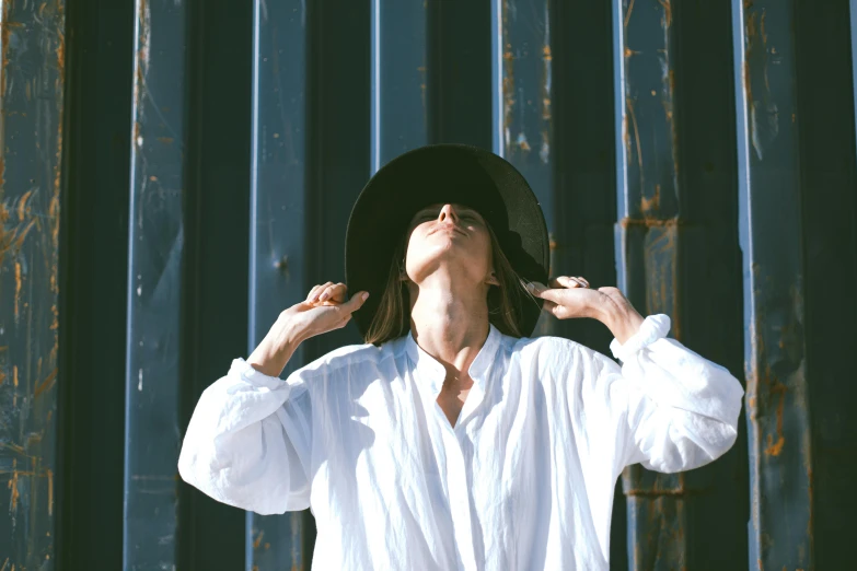 a woman in a white shirt and black hat, pexels contest winner, expressive pose, jenny seville, looking upward, white