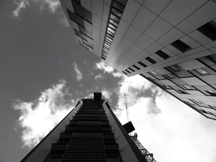 a black and white photo of a tall building, a black and white photo, unsplash, three towers, sky view, taken in the late 2010s, four stories high