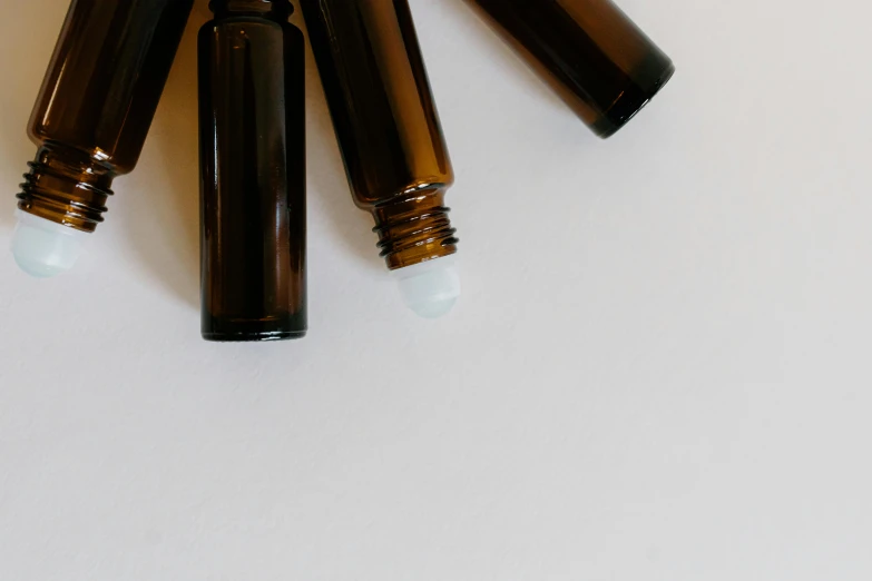 a group of brown bottles sitting on top of a white table, by Emma Andijewska, trending on pexels, healing tubes, blank, verbena, screens