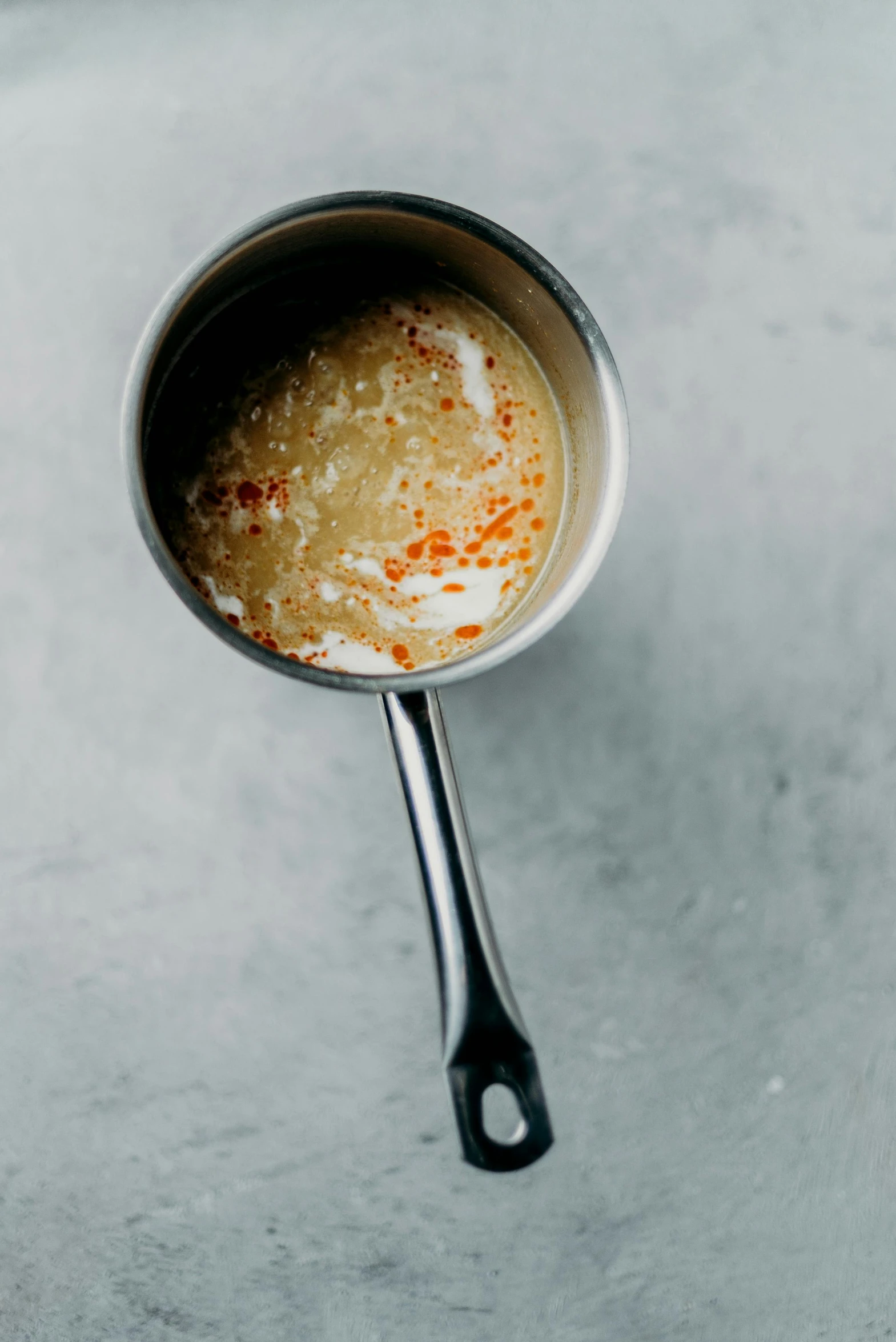 a cup of soup sitting on top of a counter, metallic flecks, holding hot sauce, thumbnail, ignant