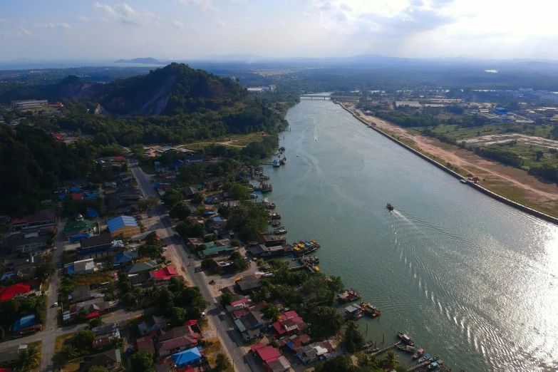 a river running through a lush green countryside, by Daniel Lieske, pexels contest winner, hurufiyya, tropical coastal city, harbour in background, thailand, helicopter footage over city