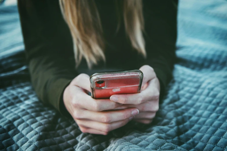 a close up of a person holding a cell phone, inspired by Elsa Bleda, pexels, square, teenager girl, red and grey only, someone sits in bed