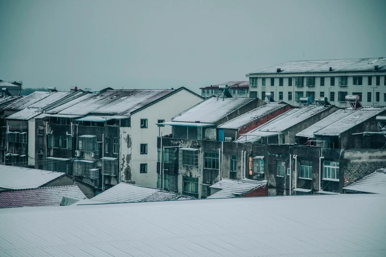 a group of buildings sitting on top of a snow covered slope, inspired by Elsa Bleda, pexels contest winner, hyperrealism, roofs, grey, white, suburb